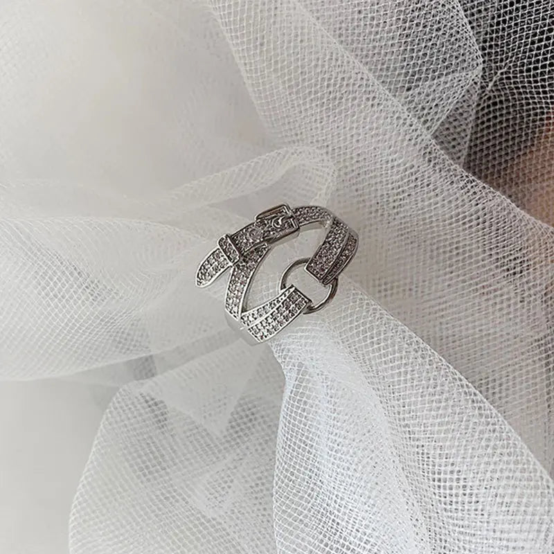 Curved diamond contour wedding band in elegant silver finish, shown on hand with blue matte nails. Stylish gold and white gold ring for special occasions.