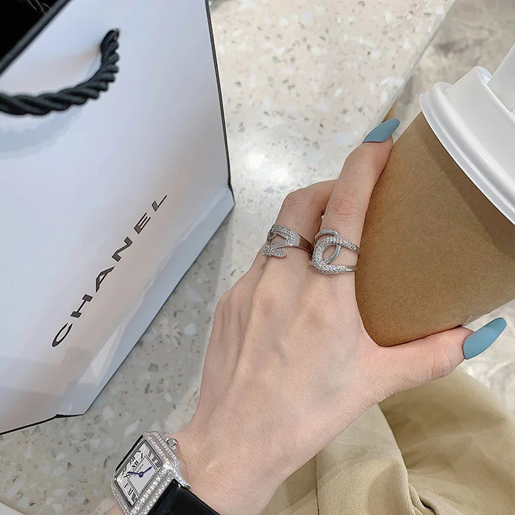 Curved diamond contour wedding band in elegant silver finish, shown on hand with blue matte nails. Stylish gold and white gold ring for special occasions.