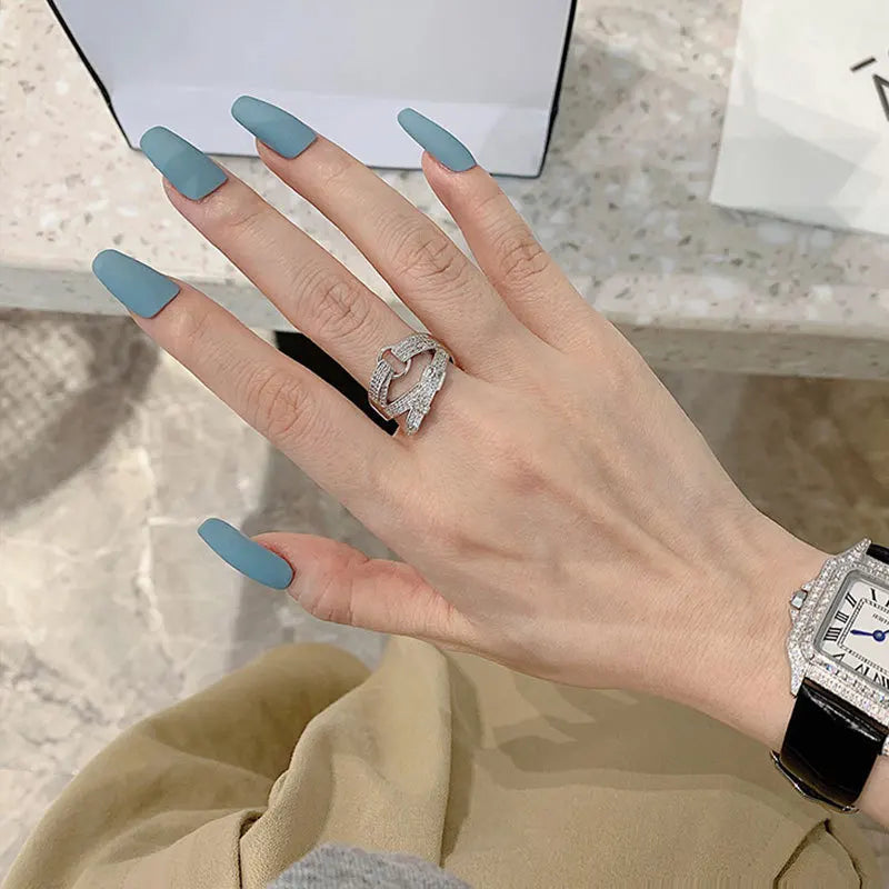 Curved diamond contour wedding band in elegant silver finish, shown on hand with blue matte nails. Stylish gold and white gold ring for special occasions.