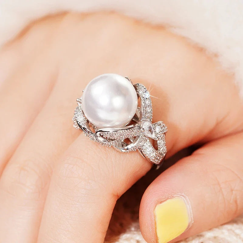 Huitan romantic bridal ring for women featuring a large pearl centerpiece and elegant twisted band with sparkling pavé stones, ideal for weddings.