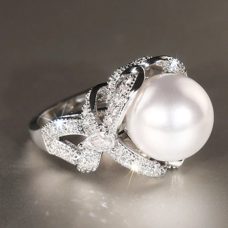 Huitan romantic bridal ring for women featuring a large pearl centerpiece and elegant twisted band with sparkling pavé stones, ideal for weddings.