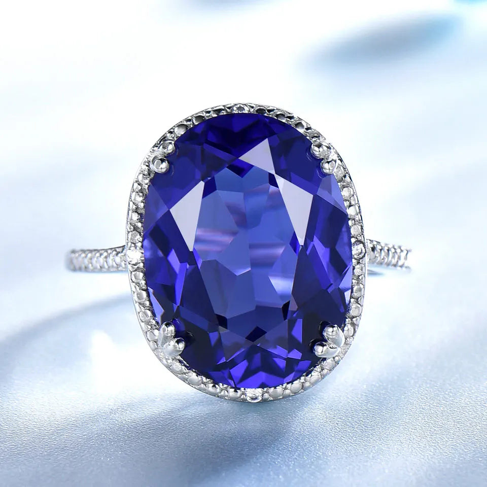 Elegant Silver Wedding Ring with round-cut Tanzanite Zircon on hand, showcasing fine jewelry craftsmanship for engagements or weddings.