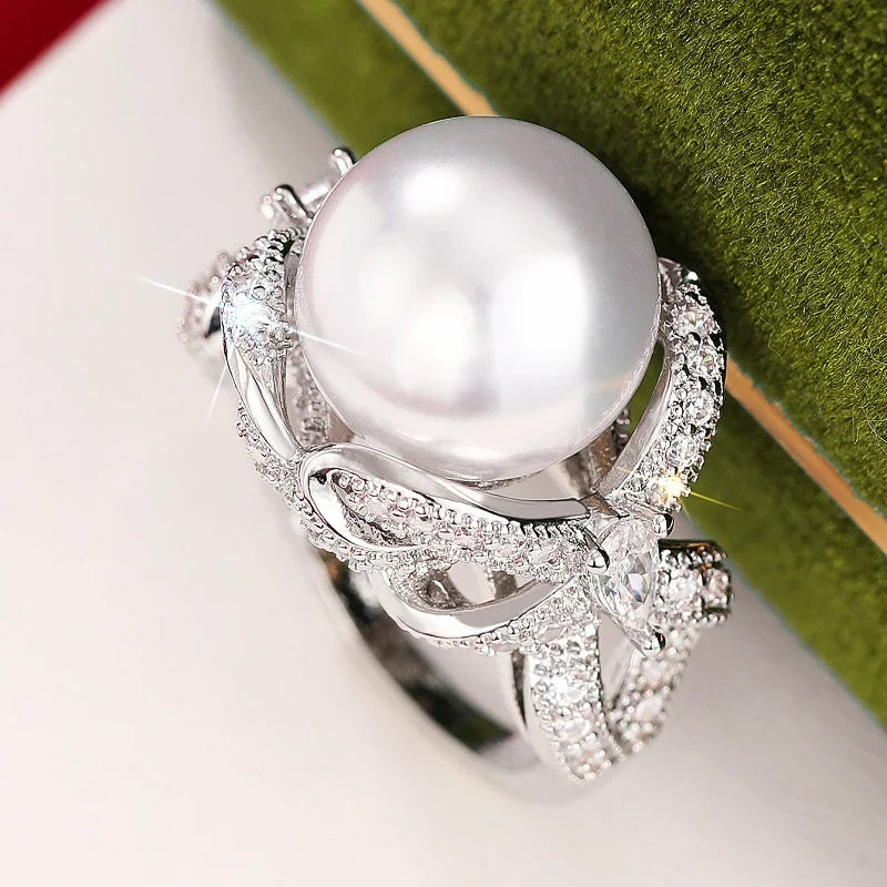 Huitan romantic bridal ring for women featuring a large pearl centerpiece and elegant twisted band with sparkling pavé stones, ideal for weddings.