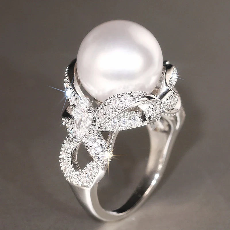 Huitan romantic bridal ring for women featuring a large pearl centerpiece and elegant twisted band with sparkling pavé stones, ideal for weddings.