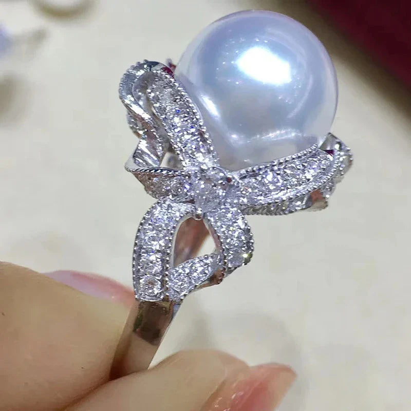 Huitan romantic bridal ring for women featuring a large pearl centerpiece and elegant twisted band with sparkling pavé stones, ideal for weddings.