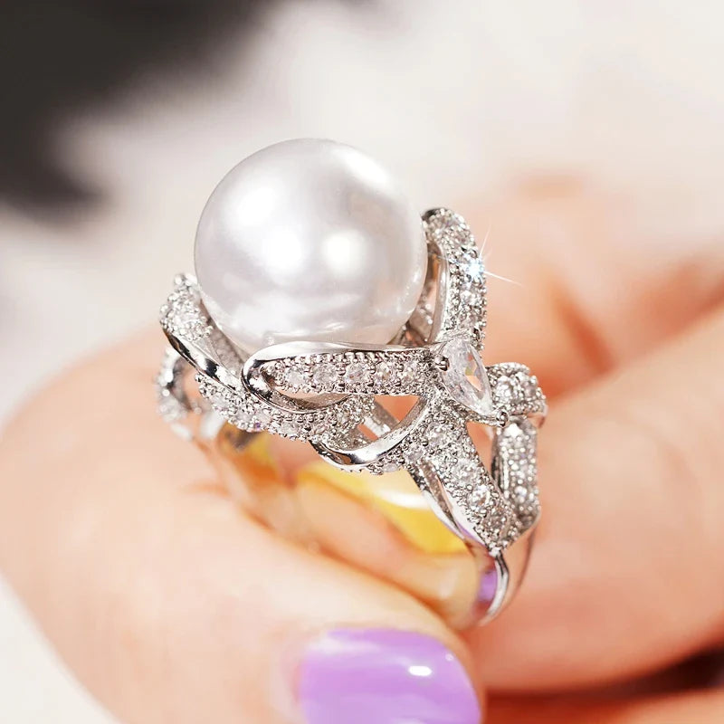 Huitan romantic bridal ring for women featuring a large pearl centerpiece and elegant twisted band with sparkling pavé stones, ideal for weddings.