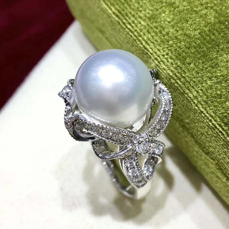 Huitan romantic bridal ring for women featuring a large pearl centerpiece and elegant twisted band with sparkling pavé stones, ideal for weddings.