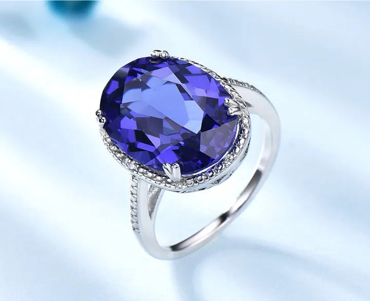 Elegant Silver Wedding Ring with round-cut Tanzanite Zircon on hand, showcasing fine jewelry craftsmanship for engagements or weddings.
