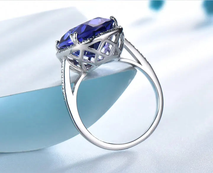 Elegant Silver Wedding Ring with round-cut Tanzanite Zircon on hand, showcasing fine jewelry craftsmanship for engagements or weddings.